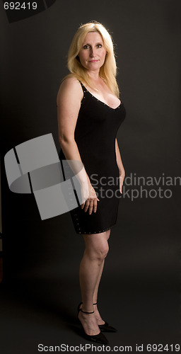 Image of glamorous middle age woman posing in black dress