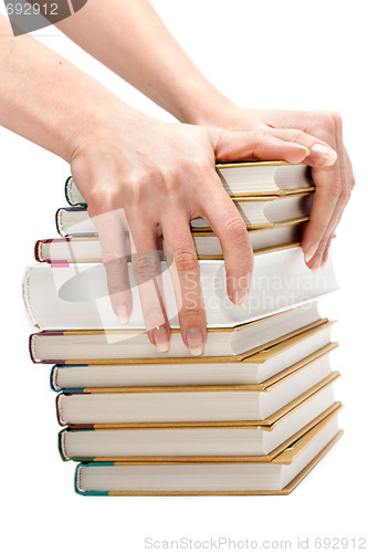 Image of Feminine hands keeps pile of the books