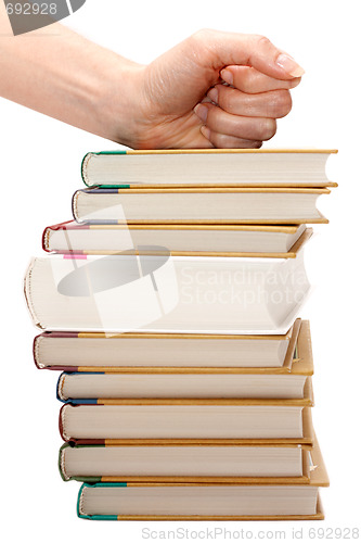 Image of Feminine fist on pile of the books