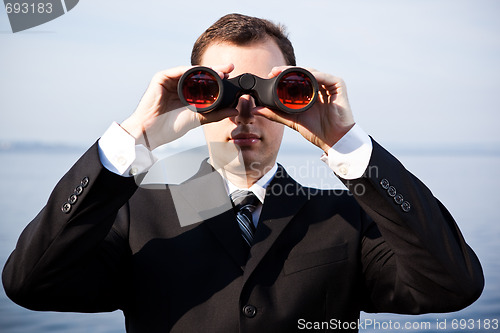 Image of Caucasian businessman with binoculars