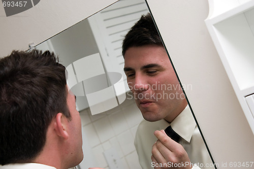 Image of Checking Himself in the Mirror