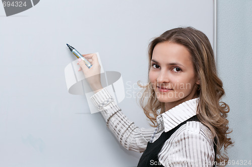 Image of Girl beside boards with marker in hand