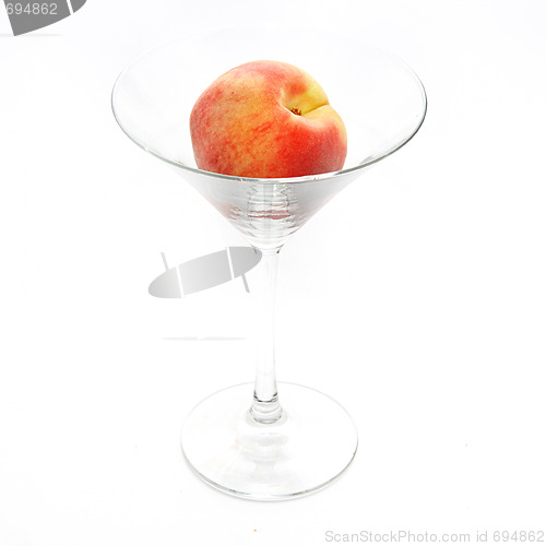 Image of The fresh peach in the martini glass isolated on white backgroun