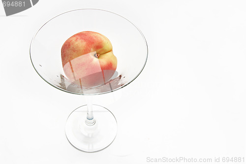 Image of The fresh peach in the martini glass isolated on white backgroun