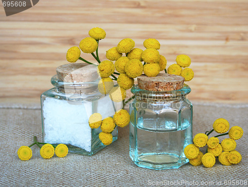 Image of Bottles of essential oil and sea salt in spa composition