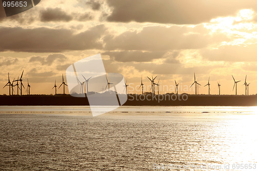 Image of Wind turbines at sunrise or sunset on the sea