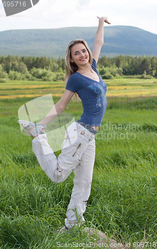 Image of Beautiful girl stand on one leg in green field
