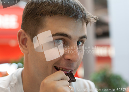 Image of Young man eats chocolate