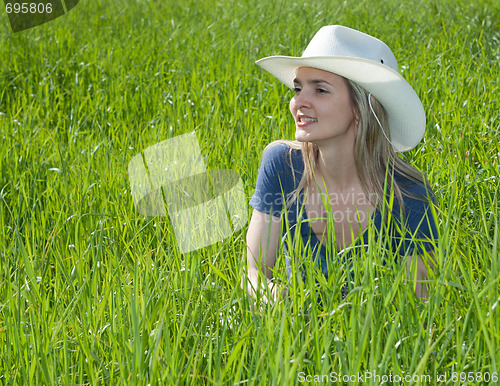 Image of Girl smiles in hat on the green herb