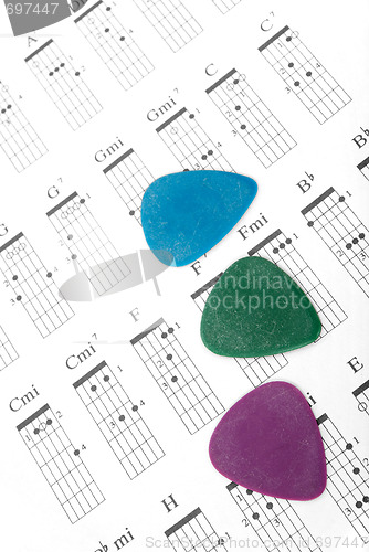 Image of Colorful guitar picks on a chords chart