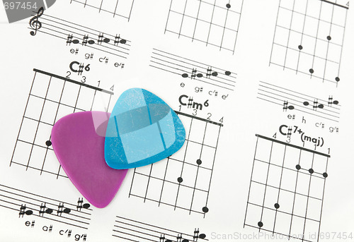 Image of Guitar picks on a chords chart