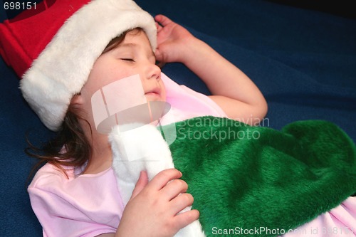 Image of Cute little girl holding Christmas stocking