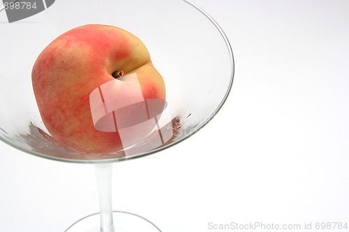 Image of The fresh peach in the martini glass isolated on white backgroun