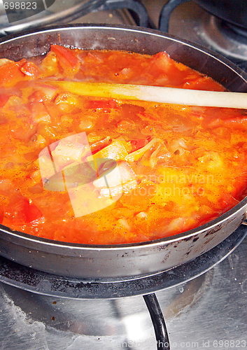 Image of Healthy cooking. The pot with fresh vegetables in the tomato sau