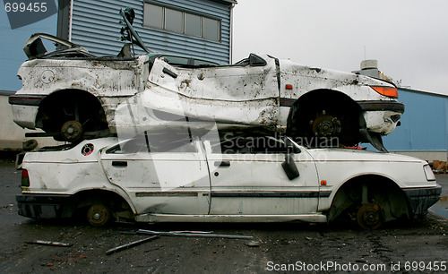 Image of Two white cars on junk yard