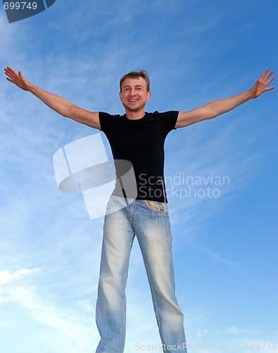 Image of young happy man with open arms outdoors