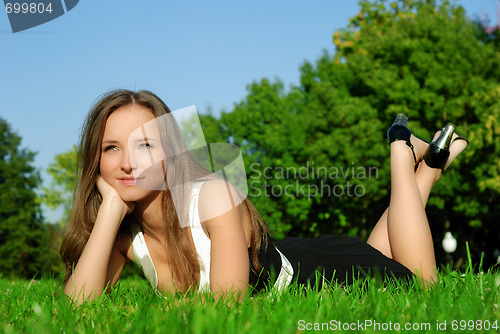 Image of girl relaxing outdoors lying on the grass