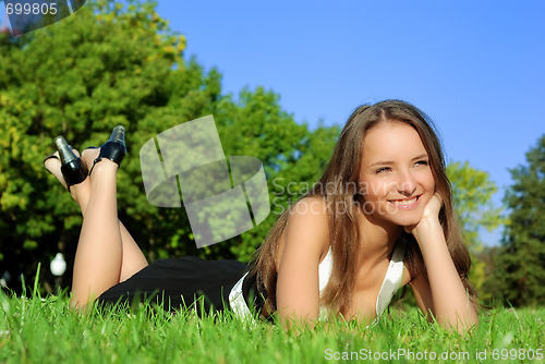 Image of girl relaxing outdoors lying on the grass