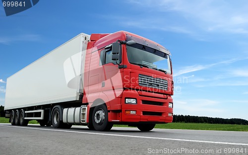 Image of red lorry with white trailer over blue sky