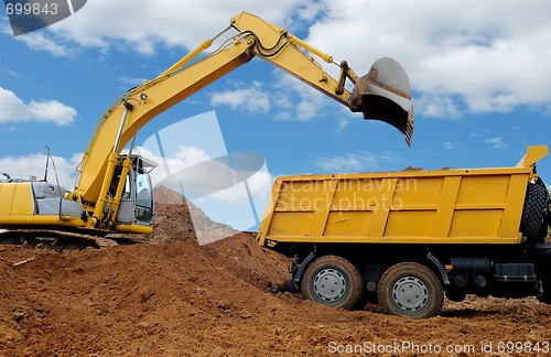 Image of Excavator loading dumper truck
