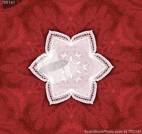 Image of lace star on red tapestry