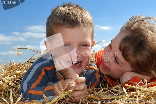 Image of smiling boy and girl in straw outdoors close-up