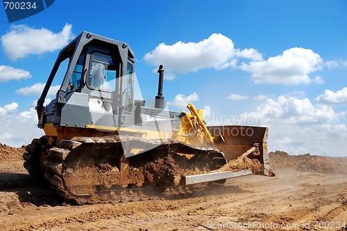 Image of bulldozer with raised blade in action 