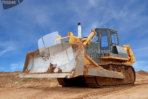 Image of Heavy bulldozer with half raised blade in sandpit