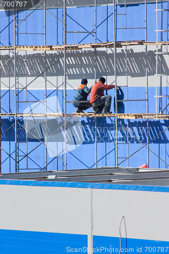 Image of Two workers on industrial object