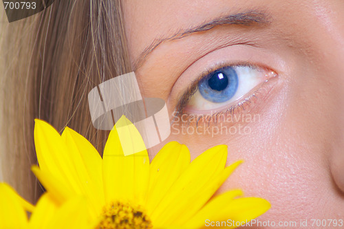 Image of Female eye with a yellow flower