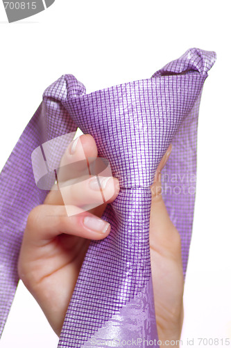 Image of Female hand holding a violet tie with the fastened knot