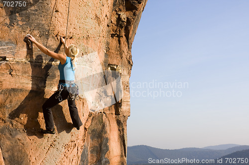 Image of Young woman climbing