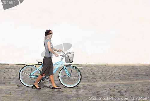 Image of Woman with a bicycle in a city