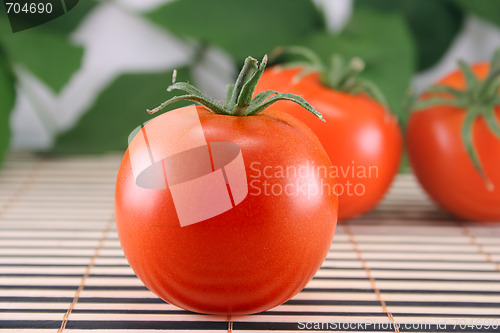 Image of Three tomatoes on bamboo napkin