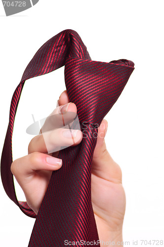 Image of Female hand holding a red striped tie with the fastened knot
