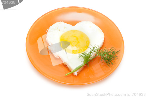 Image of Fried egg in form heart on plate with dill
