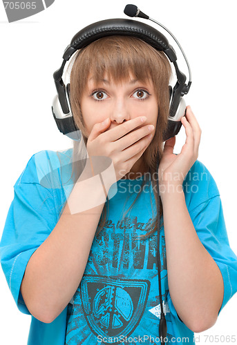 Image of Beautiful girl in earphone closes mouth by hand