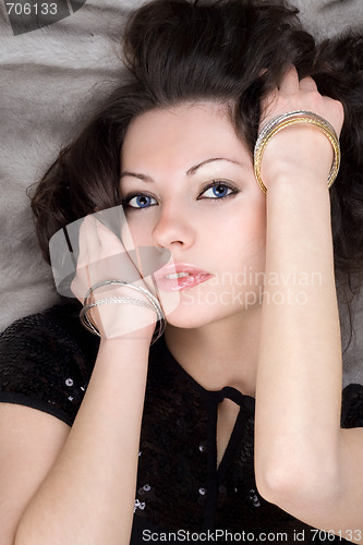 Image of Portrait of the attractive lady lying on grey fur