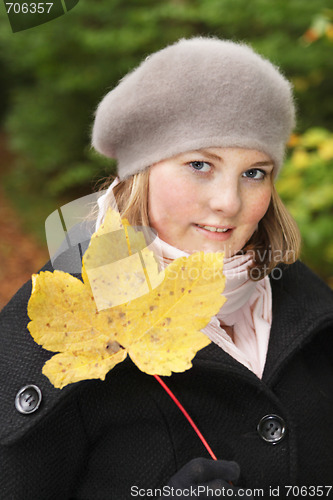 Image of Cute young woman showing maple leave