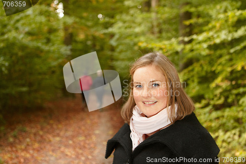 Image of Autumn - Woman in forest smiling 