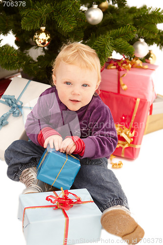 Image of Cute little girl opening christmas gifts