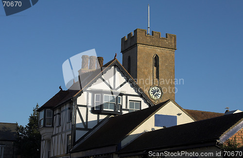 Image of church clock tower with timber building