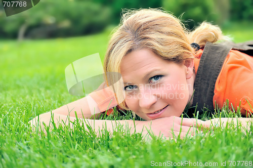 Image of Young woman relaxing on the grass