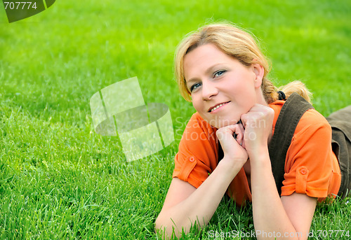 Image of Young woman relaxing on the grass