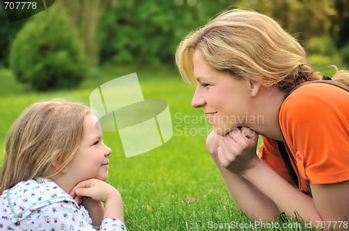Image of Young mother and daughter laying on the grass
