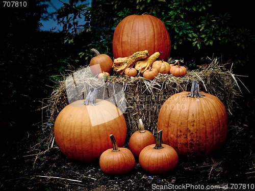 Image of Pumpkins on a hay bale at dusk