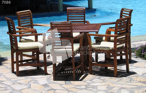Image of Complete furniture set by the swimming pool at a resort on a sunny day