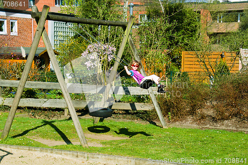 Image of Small girl on playground swing