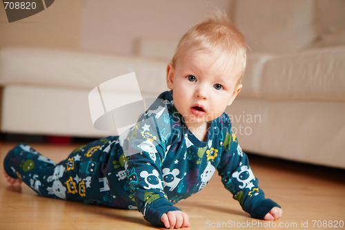 Image of 6 mobth old baby crawling on floor at home