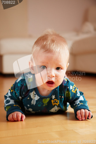 Image of 6 mobth old baby crawling on floor at home